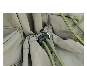 Primer plano detallado de la mochila de nailon verde oliva con cierre de cordón.