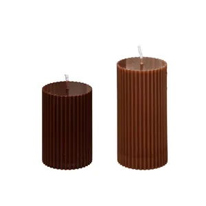 Detailed view of two ribbed cylindrical pillar candles in different brown shades