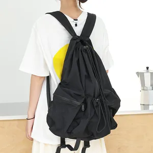Mochila minimalista de nailon negro con cordón ajustable y modernos detalles plisados.