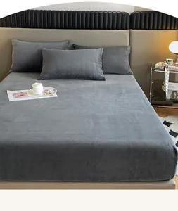 Vista detallada del juego de sábanas bajeras y fundas de almohada de terciopelo gris suave