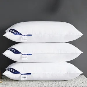 Almohadas de hotel de algodón blanco con relleno de seda de pluma en pila vertical
