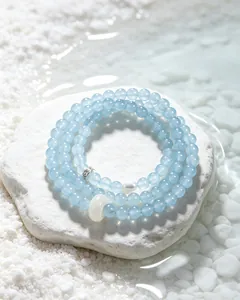Detail of light blue chalcedony beaded bracelet with white agate runner bead on water