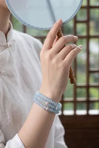 Close-up of triple-layer blue chalcedony beaded bracelet with pearl on woman's wrist