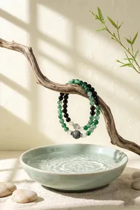 Detailweergave van een armband van groene chalcedoon en obsidiaan aan een natuurlijke tak