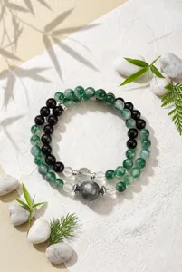 Macrodetail van mosagaat en obsidiaan kralenarmband met transparante kralen