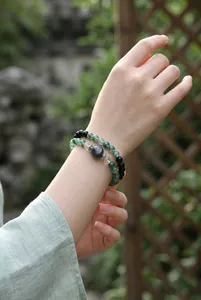 Detailopname van een mosagaat en obsidiaan kralenarmbandset, vintage Chinese stijl.
