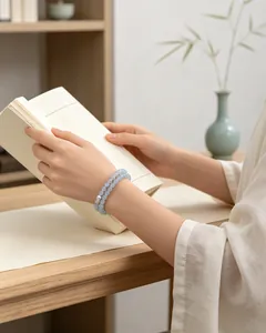 Close-up of elegant blue chalcedony beaded bracelet worn on wrist while reading