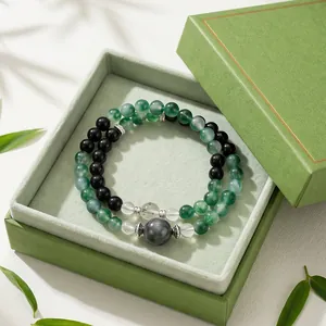 Elegante armband van mosagaat en zwarte obsidiaan in een groene geschenkverpakking