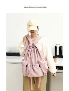 Mochila informal de nailon plisado rosa con cordón, llevada por modelo, estilo minimalista