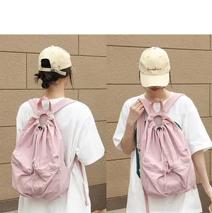Rosa plissierter Nylon-Rucksack mit Kordelzug in Vorder- und Rückansicht an einem Model