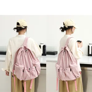 Vista trasera detallada de una mochila casual de nailon rosa con pliegues y cordón