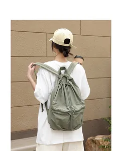 Rückansicht eines lässigen salbeigrünen Nylon-Rucksacks mit Kordelzug und Faltenstruktur