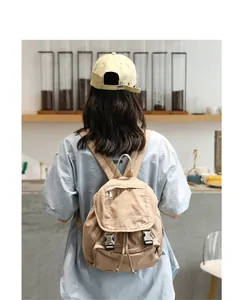 Mochila de lona lavada vintage para mujer en una elegante cafetería japonesa.