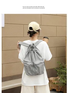Rückansicht eines grauen, gefalteten Nylon-Kordelzug-Rucksacks im lässigen Outdoor-Stil