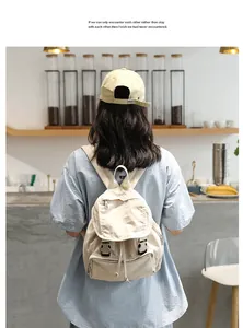 Vista trasera de una mochila de lona beige vintage llevada por una modelo