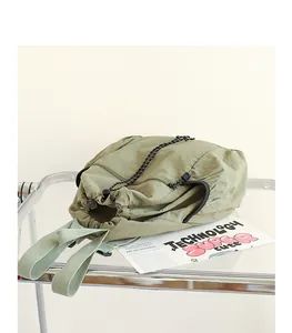 Detailansicht eines grünen plissierten Nylon-Rucksacks mit Kordelzug und Textur