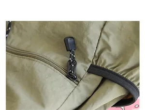 Nahaufnahme von Reißverschluss und strukturiertem Nylongewebe an salbeigrünem Rucksack