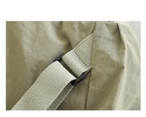 Detailaufnahme der verstellbaren Riemen und Schnalle an einem olivgrünen Nylonrucksack