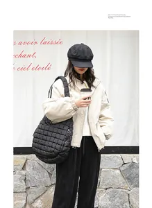 Fashionable black quilted nylon shoulder bag with pleated design and padded strap
