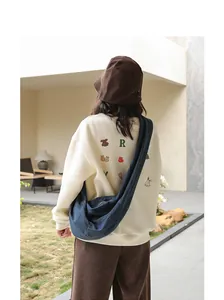 Casual Japanese denim dumpling crossbody bag worn by model in an outdoor courtyard