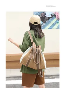 Modelo luce una mochila de lona caqui y blanca en un entorno exterior muy informal