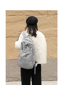 Vista trasera de una mochila de nylon gris con cordón y gran capacidad de almacenamiento