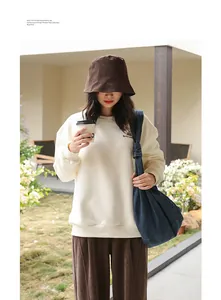 Model wearing a navy blue denim dumpling bag with a stylish knotted shoulder strap