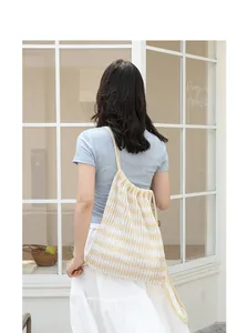 Mochila de punto a rayas de estilo japonés con cordón mostrada en la espalda de modelo