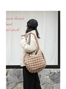 Close-up of beige quilted nylon puff shoulder bag with soft padded texture