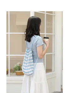 Detalle de estilo de vida de mochila de ganchillo a rayas azules y blancas con cordón