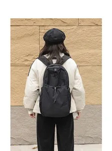 Vista detallada de la espalda de una mochila japonesa de nailon negro con cordón ajustable