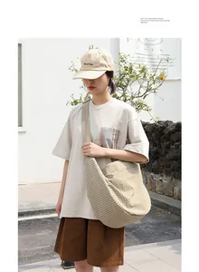 Modelo con un bolso bandolera japonés de lona a cuadros en un tono color beige.