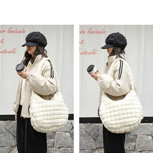 Detailed side view of white quilted nylon shoulder bag on a female model