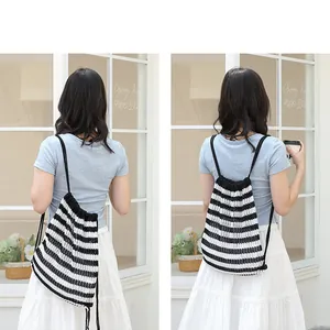 Vista de detalle de una mochila de punto a rayas blancas y negras en una modelo