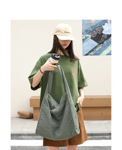 Primer plano de un bolso tote de lona a cuadros verdes llevado por una modelo con estilo casual.