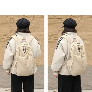 Vista posterior detallada de una mochila de nailon beige con cordón y mosquetón negro