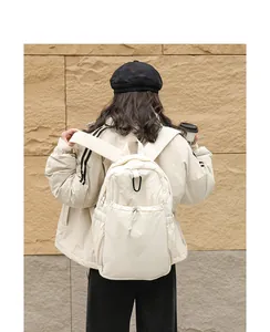 Vista trasera de una mochila de nailon crema con pliegues, cordón y gran capacidad.