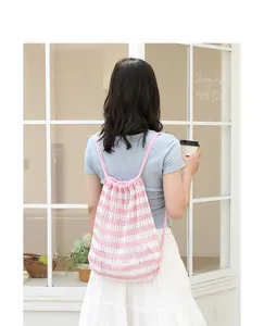 Detalle de estilo de vida de una mochila de punto a rayas rosas y blancas con cordón