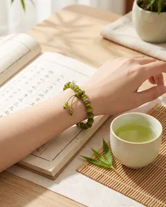 Detailed lifestyle shot of an olive green cat's eye beaded bracelet on a woman's wrist