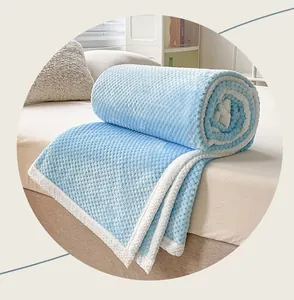 Primer plano de una manta azul con textura de rejilla de piña y borde de felpa blanca