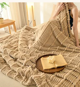 Detail view of a cozy tan striped flannel blanket on a bed with lifestyle props