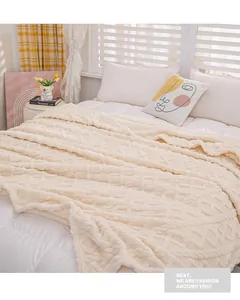 Texture detail of a cozy cream embossed coral fleece throw blanket styled on a bed