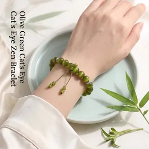 Elegant olive green cat-eye beaded bracelet with Zen style design worn on model's wrist