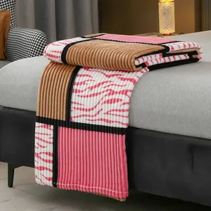 Coperta in flanella patchwork con strisce a coste rosa e marroni e motivo zebrato.