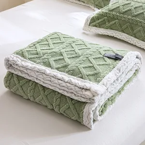 Soft green velvet blanket with white braided border and textured diamond pattern