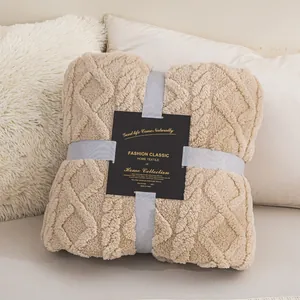 Folded beige coral fleece blanket with textured diamond pattern and gift ribbon