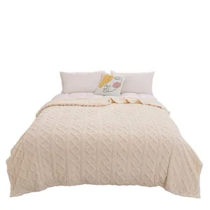 Cozy cream coral fleece blanket with beautiful cable knit texture on a modern bed setup