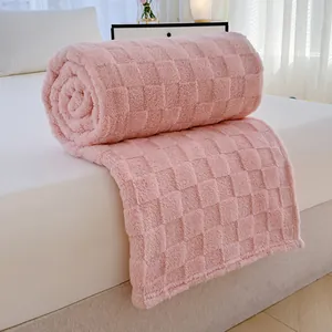 Weiche rosa flanell fleecedecke mit karomuster ordentlich auf weißem bett gerollt