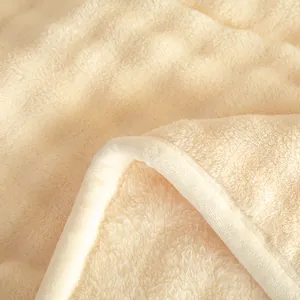 Detail view of a soft cream milk velvet fleece blanket with cozy plush texture for home and office
