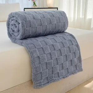 Weiche graue Flanell-Kuscheldecke mit Waffelmuster auf einem gemütlichen Bett im Schlafzimmer